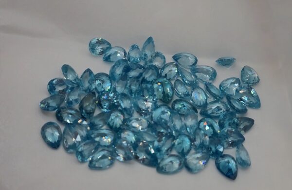 Lot of pear-shaped faceted natural neon blue zircon gemstones from Cambodia, displaying sparkling clarity and color